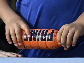 FILE - A child holds a PRIME hydration drink prior to a baseball game between the Los Angeles Dodgers and the Arizona Diamondbacks, March 31, 2023, in Los Angeles. An influencer-backed energy drink that has earned viral popularity among children is facing scrutiny from federal lawmakers and health experts over its potentially dangerous levels of caffeine. Senator Chuck Schumer on Sunday, July 9, 2023 called on the Food and Drug Administration to investigate Prime.