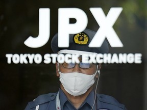 FILE - A security guard stands guard at an entrance of Tokyo Sock Exchange building, Tuesday, July 18, 2023, in Tokyo. On Friday, July 28, Japan's central bank opted to keep its benchmark interest rate at minus 0.1% but said it will fine-tune its bond purchases to allow greater flexibility given high uncertainties for the economy and for prices.