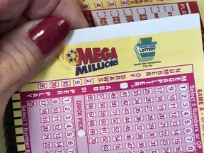 FILE - A Mega Millions wagering slip is held in Cranberry Township, Pa., Jan. 12, 2023. The Mega Millions top prize has jumped to an estimated $820 million after there was no grand prize winner in the latest drawing, late Friday, July 21, 2023.
