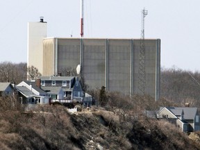 FILE - A portion of the Pilgrim Nuclear Power Station is visible beyond houses along the coast of Cape Cod Bay in Plymouth, Mass., March 30, 2011. Massachusetts environmental regulators have denied a request Monday, July 24, 2023, by the company dismantling a shuttered nuclear power plant to release more than 1 million gallons of radioactive wastewater into Cape Cod Bay.