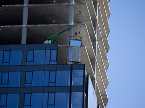 Workers install prefabricated wall sections at a condo under construction in Montreal.
