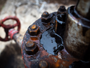 Crude oil leaks from an oil pumping jack in an oil field Russia. 