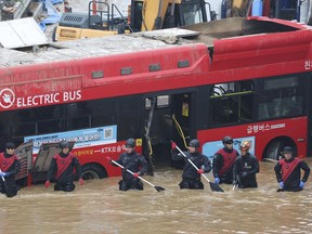 FILE - Rescuers conduct a search operation along a road submerged by floodwaters leading to an underground tunnel in Cheongju, South Korea, July 16, 2023. Countries in the Asia-Pacific region needs to drastically increase their investments in disaster warning systems and other tools to counter rising risks from climate change, a United Nations report said Tuesday, July 25, 2023.