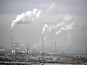 FILE - Smoke billows from chimneys of the cooling towers of a coal-fired power plant in Dadong, Shanxi province, China, Dec. 3, 2009. Frans Timmermans, the European Union's climate chief, expressed concern over the expansion of China's coal industry at a conference in Beijing on Monday, July 3, 2023.