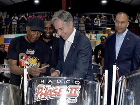 United States Secretary of State Antony Blinken, center, plays a steel pan accompanied by musician Len 'Boogsie' Sharpe, left, and Hakeem Jeffries, Minority Leader of the U.S House of Representatives, right, at the HADCO Phase II Pan Groove pan yard in Port of Spain, Trinidad and Tobago, Wednesday, July 5, 2023. Blinken is in Trinidad and Tobago to participate in the Caribbean Community, CARICOM, Heads of Government meeting.