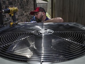 FILE - Ed Newby, owner of All Star A/C and Heating, works on an air conditioning unit on June 26, 2023, in Houston. The Environmental Protection Agency is enforcing stricter limits on hydrofluorocarbons, highly potent greenhouse gases used in refrigerators and air conditioners. A rule announced Tuesday, July 11, would impose a 40% reduction in HFCs below historic levels by 2028, part of a global phaseout of HFCs designed to slow global warming.
