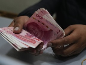 A money exchange shop worker counts Chinese yuan banknotes in La Paz, Bolivia, Wednesday, July 26, 2023. Bolivia's state-run bank, Banco Union, has started to carry out transactions using China's currency, the yuan.