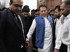 Pakistan's former Prime Minister Imran Khan arrives to sign documents as he submits surety bond over his bails in different cases at an office of Lahore High Court in Lahore, Pakistan, Tuesday, July 18, 2023.