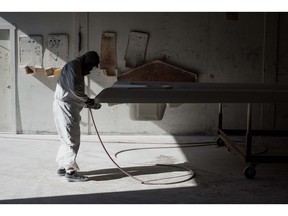 An employee sands the hull of a boat at the Everglades Boats manufacturing facility in Edgewater, Florida, U.S., on Monday, Jan. 25, 2016. Construction of vessels at the Everglades Boats factory, which is done in-house at the company's 125,000-square-foot facility, uses all fiberglass parts, aluminum fabrication of frames and rails, and all wiring harnesses. Photographer: Ty Wright/Bloomberg