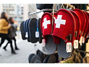 A Swiss national flag adorns a pair of novelty woolen slippers hanging on display outside a souvenir shop in Zurich, Switzerland, on Wednesday, Nov. 9, 2016. Donald Trump's ascendancy to the White House pushed the Swiss franc to the strongest level since the wake of June's Brexit vote and options prices suggest more gains are likely. Photographer: Michele Limina/Bloomberg