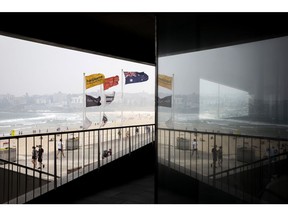 Flags fly from pole as Bondi beach is shrouded in haze in Sydney, New South Wales, Australia, on Wednesday, Jan. 8, 2020. As Sydney faced another day of toxic haze shrouding the skyline, U.S. weather satellite captured the smoke crossing South America and spreading out over Buenos Aires before it drifted into the Atlantic Ocean -- some 7,328 miles (11,793 kilometers) east of Sydney -- according to the National Oceanic and Atmospheric Administration. Photographer: Brent Lewin/Bloomberg