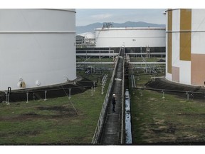 A worker stand next to oil storage tanks at the Pilipinas Shell Petroleum Corp. Shell Import Facility Tabangao (SHIFT) in Batangas City, the Philippines, on Monday, March. 7, 2022. Oil soared in Asia -- jumping as much as 18% early in the session -- after reports that the U.S. was discussing a ban on Russian crude imports sent shock waves through an already-reeling market. Photographer: Veejay Villafranca/Bloomberg