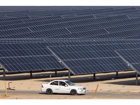 A car travels past photovoltaic panels at the Al Dhafra Solar project, constructed by Electricite de France SA (EDF) and Jinko Power Technology Co. Ltd., in Abu Dhabi, United Arab Emirates, on Tuesday, Jan 31, 2023. During a visit to the site French Economy Minister Bruno Le Maire said to journalists "We are interested and we will see what the decision of Saudi Arabia will be," in response to question about bidding for the kingdom's first nuclear plant.