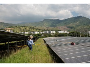 A worker cleans solar panels at the Celsia solar farm facility in Yumbo, Valle del Cauca department, Colombia, on Wednesday, April 12, 2023. Power generator Celsia rose as much as 8.4% after a court suspended a decree from President Gustavo Petro that would have allowed him to cut residential energy tariffs.