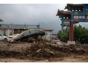 Vehicles stranded in mud following Typhoon Doksuri in the Mentougou district of Beijing, China, on Thursday, Aug. 3, 2023. The deluge of rain that triggered floods and killed at least 20 people in northern China this week was the heaviest to hit Beijing since record-keeping began in the 19th century. Bloomberg