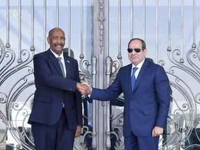 In this photo provided by Egypt's presidency media office, Egyptian President Abdel-Fattah el-Sissi, right, greets Sudan's army chief General Abdel Fattah al-Burhan at the Presidential palace in el-Alamein city, Egypt, Tuesday, Aug. 29, 2023. (Egyptian Presidency Media Office via AP)