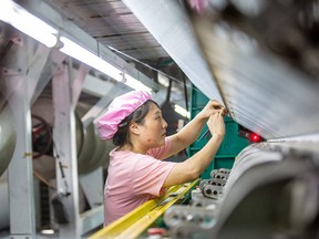 A woman works in a textile factory in Haian city in China's eastern Jiangsu Province. China has seen a string of misses on economic data after coming out of one of the longest-standing COVID-19 clampdowns in the world.