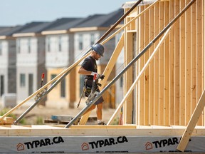 A construction worker builds a new house in London, Ontario.