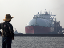 A man looks out towards a liquefied natural gas (LNG) tanker berthed at Tokyo Electric Power Co.'s (Tepco) Futtsu gas-fired thermal power plant in Futtsu, Chiba Prefecture, Japan.