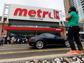 Workers are seen on a picket line outside a Metro grocery store in Toronto in July. Metro says it has reached a tentative agreement with Unifor that could end the strike.