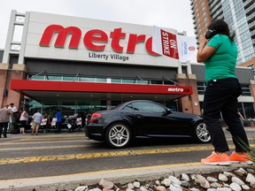 Workers seen on strike outside a Metro grocery store in Toronto.