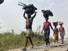 FILE - Women and children return from their farmlands after the day's work in Agatu village on the outskirts of Benue State in Nigeria, Wednesday, Jan 5, 2022. Nigeria's statistics agency on Thursday, Aug. 24, 2023, reported the country's unemployment rate as 4.1%, the lowest in many years, but one which analysts said was an undercount because of the agency's new methodology. In its new labor force report, the bureau said about three in four working-age Nigerians aged at least 15 were employed in the first quarter of 2023.