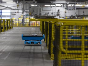 A robot carries a package at an Amazon warehouse in Acheson, Alta.