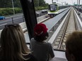 People look out the window of an REM train near Montreal.