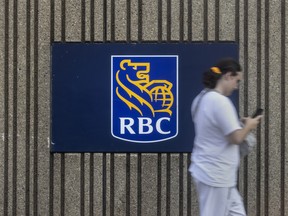 A pedestrian passes Royal Bank of Canada signage in Brampton, Ont.