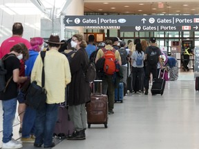 People line up before entering the security at Pearson International Airport in Toronto.