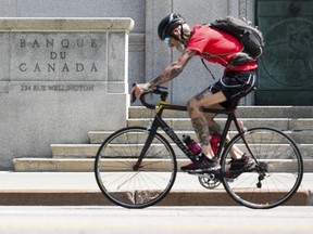 A cyclist makes his way past the Bank of Canada in Ottawa.