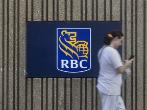 A pedestrian passes RBC signage in Brampton, Ont.