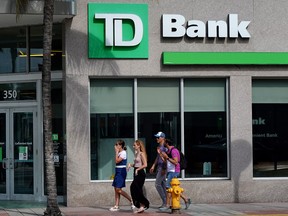 People walk past a Toronto-Dominion Bank in Miami Beach, Florida.
