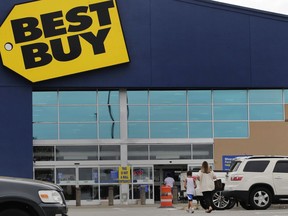 FILE - A woman walks with a boy to the Best Buy store at the Mall of New Hampshire, Tuesday, Aug. 4, 2020, in Manchester, N.H. Best Buy sales and profits slid in the second quarter, Tuesday, Aug. 29, 2023, as the nation's largest consumer electronics chain continues to wrestle with a pullback in spending on gadgets after Americans splurged during the pandemic.