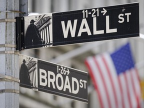 A U.S. Flag hangs in the background at the corner of Wall and Broad Streets in the heart of the Financial District in New York City, Tuesday, Aug. 1, 2023. Stocks are taking a step back Tuesday from their big surge for the year so far following a mixed set of earnings reports from U.S. companies.