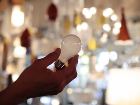 FILE - Manager Nick Reynoza holds a 100-watt incandescent light bulb at Royal Lighting in Los Angeles, Jan. 21, 2011. New federal rules governing the energy efficiency of lighting systems went into full effect Tuesday, effectively ending the sale and manufacture of bulbs that trace their origin to an 1880 Thomas Edison patent.