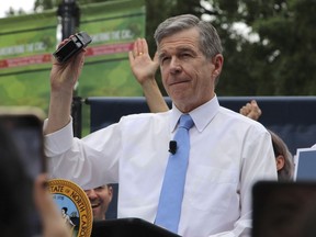 FILE - North Carolina Democratic Gov. Roy Cooper affixes his veto stamp to a bill banning nearly all abortions after 12 weeks of pregnancy at a public rally, May 13, 2023, in Raleigh, N.C. Transgender rights take center stage in North Carolina again Wednesday, Aug. 16, as GOP supermajorities in the General Assembly attempt to override the governor's vetoes of legislation banning gender-affirming health care for minors and limiting transgender participation in school sports.