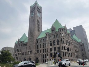 FILE - Cars drive past Minneapolis City Hall, June 28, 2023, in Minnesota. Minneapolis City Council members narrowly passed a measure on Thursday, Aug. 17, that would establish a minimum wage for drivers of Uber, Lyft and other ride-share companies in the city.