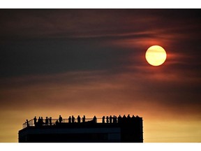 The sun goes down behind smoke from wildfires, in Tejo Park, Lisbon, on Aug. 5. Photographer: Marco Bertorello/AFP/Getty Images