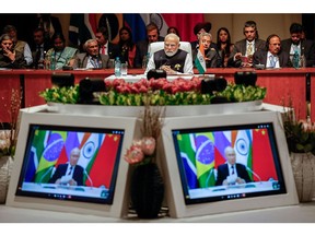 Narendra Modi, center, at the plenary session as Vladimir Putin delivers his remarks virtually during the 2023 BRICS Summit in Johannesburg on Aug. 23. Photographer: Gianluigi Guercia/AFP/Getty Images