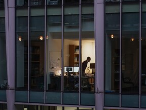 A report by recruiting company Robert Half says just over half of hiring managers see a team's ideal working location to be a combination of remote and in-office workers. A worker in an office in the financial district The City, in London, Monday, Dec. 13, 2021.