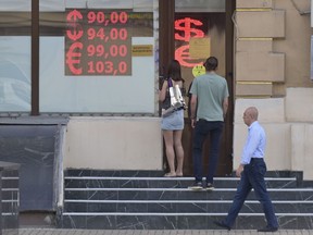 FILE - People enter a currency exchange office in Moscow, Russia, Thursday, July 6, 2023. The Russian ruble has reached its lowest value since the early weeks of the war in Ukraine as Western sanctions weigh on energy exports and weaken demand for the national currency. On Monday Aug. 14, 2023, the Russian currency passed 101 rubles to the dollar, continuing a more than 25% decline in its value since the beginning of the year and hitting the lowest level in almost 17 months.