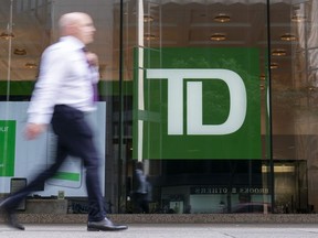TD Bank Group reported its third-quarter profit fell compared with a year ago as its provisions for credit losses rose. A person makes their way past a Toronto-Dominion Bank in the Financial District of Toronto, Monday, Aug. 14, 2023.