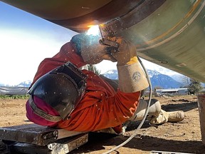 A welder working on a section of pipeline.