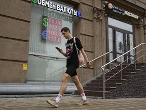 A man walks past a currency exchange office in Moscow, Russia, Monday, Aug. 14, 2023. The Russian ruble has reached its lowest value since the early weeks of the war in Ukraine as Western sanctions weigh on energy exports and weaken demand for the national currency. The Russian currency passed 101 rubles to the dollar on Monday, continuing a more than 25% decline in its value since the beginning of the year.