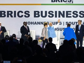 Indian Prime Minister Narendra Modi waves at the start of the BRICS group of emerging economies three-day summit in Johannesburg, South Africa, Tuesday, Aug. 22, 2023. From left, Brazilian President Luiz Inácio Lula da Silva, South African President Cyril Ramaphosa , Modi and China minister of commerce Wang Wentao. They will be joined by Russian President Vladimir Putin who will appear on a video link after his travel to South Africa was complicated by an International Criminal Court arrest warrant against him over the war in Ukraine.