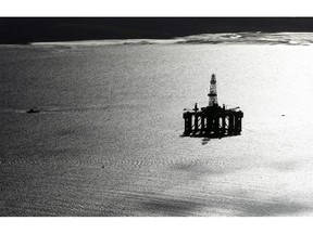 A boat passes a mobile offshore drilling unit in the Port of Cromarty Firth in Cromarty, U.K., on Wednesday, March 22, 2017. Even as oil production declined in the North Sea over the last 15 years, economic activity has been buoyed by offshore windmills.