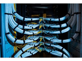 Fiber optic cables, center, and copper Ethernet cables feed into switches inside a communications room at an office in London, U.K., on Monday, May 21, 2018. The Department of Culture, Media and Sport will work with the Home Office to publish a white paper later this year setting out legislation, according to a statement, which will also seek to force tech giants to reveal how they target abusive and illegal online material posted by users.