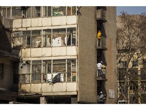 Residents gather on the balconies of a dilapidated residential apartment block in the Central Business District (CBD) of Johannesburg, on Thursday, May 7, 2020. Almost one million people in Johannesburg, South Africa's commercial hub, are in need of food aid due to movement restrictions imposed to curb the coronavirus pandemic, according to its mayor.
