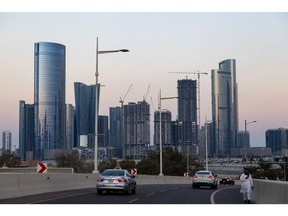 Motorists drive onto Al Reem Island, backdropped by residential high-rise buildings in Abu Dhabi, United Arab Emirates, on Thursday, Nov. 24, 2022. The UAE, Saudi Arabia and Qatar are all pushing to diversify their economies before the fossil-fuel era ends and are well-positioned to take advantage of opportunities opening up, especially as the US and Europe face higher financing costs and China struggles with Covid. Photographer: Christopher Pike/Bloomberg